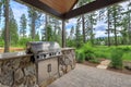 Beautiful back yard stone and brick patio with BBQ grill and luxury setting Royalty Free Stock Photo