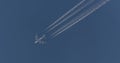 Civil plane leaving traces of smoke in the blue sky Royalty Free Stock Photo