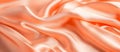 Beautiful background luxury cloth with drapery and wavy folds of peach fuzz color creased smooth silk satin material Royalty Free Stock Photo