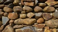 Beautiful background pattern image of a wall made of round stone red color rocks. Texture Royalty Free Stock Photo