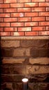 Beautiful background. Texture of a section of stone and brick wall illuminated by a halogen light