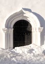 Beautiful background of white church fragment with iron wrought door on winter day at sunset Royalty Free Stock Photo