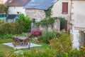 Beautiful backyard with outdoor furniture and flowers. Empty patio of old house in village, France. Rural yard. Royalty Free Stock Photo