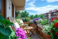 Beautiful balcony with comfortable chairs, wooden table and many potted flowers plants. Generative AI