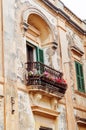 Beautiful balcony with flower pots and French doors in Mdina, Malta.