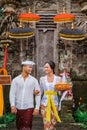 balinese couple going to pura to pray and make offering to the god