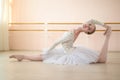 Beautiful ballerina in the body and white tutu practicing in dance class and sitting in the splits. Young flexible Royalty Free Stock Photo