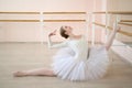 Beautiful ballerina in the body and white tutu practicing in dance class and sitting in the splits. Young flexible Royalty Free Stock Photo