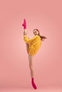 Flexible young beautiful girl, female ballet dancer training isolated over pink background. Royalty Free Stock Photo