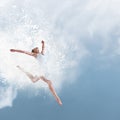 Beautiful ballet dancer jumping with cloud of powder