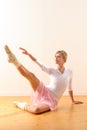 Beautiful ballet dancer lifting arm towards leg Royalty Free Stock Photo