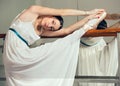 Beautiful ballet dancer in white tutu posing on one leg next to handle bar. Royalty Free Stock Photo