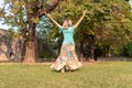 Beautiful barefoot girl in a long colorful skirt is dancing