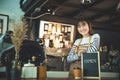 Beautiful barista holding blackboard