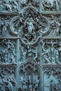 Beautiful bas-reliefs on the bronze door of  building of the Milan Cathedral Duomo di Milano, the cathedral church of Milan, Royalty Free Stock Photo