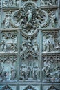 Beautiful bas-reliefs on the bronze door of  building of the Milan Cathedral Duomo di Milano, the cathedral church of Milan, Royalty Free Stock Photo