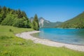 Beautiful bathing beach lake Walchensee, green forest and Herzogstand mountain view