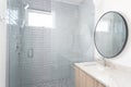 A bathroom with a wood cabinet and grey tiled shower. Royalty Free Stock Photo