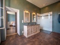 Beautiful bathroom interior with wooden cabinets and a walking shower near a bedroom