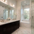 Beautiful bathroom in luxury home with double vanity bathtub and shower Features herringbone tile on floor and marble tile on Royalty Free Stock Photo