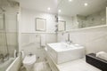 Beautiful bathroom with white marble tiles with a mirror integrated into the wall, an educational cabin with a glass partition and Royalty Free Stock Photo