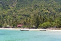 Beautiful bay with coconut palm trees and boats. Tropical sand beach and sea water on island Koh Phangan, Thailand Royalty Free Stock Photo