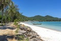 Beautiful bay with dirt road, blue sea water, coconut palm trees and boats. Tropical sand beach and sea water on island Koh Royalty Free Stock Photo