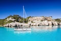 Beautiful bay in Mediterranean sea with sailing boat, Menorca island, Spain. Yachting, travel and active lifestyle concept Royalty Free Stock Photo