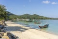 Beautiful bay with palm trees and boats. Tropical beach and sea water on the island Koh Phangan, Thailand