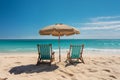 Beautiful beach. Chairs on the sandy beach. Two sun loungers and a beach umbrella on the sand against the backdrop of the sea.