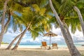 Beautiful beach. Chairs under palm trees sandy beach sea. Summer holiday and vacation concept for tourism. Inspirational beach Royalty Free Stock Photo