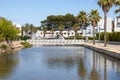 The beautiful beach front on the Island of Majorca in Spain showing a bridge going over water by holiday homes on a hot sunny Royalty Free Stock Photo