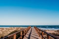 beautiful beach landscape at sunset. wooden bridge path. blue sky