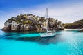 Beautiful beach with sailing boat yacht, Cala Macarelleta, Menorca island, Spain. Yachting, travel and active lifestyle concept Royalty Free Stock Photo
