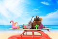 Vintage Retro beetle car with luggage and beach stuff on roof ready for summer vacation on beach in sunny Royalty Free Stock Photo