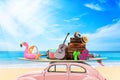 Vintage Retro beetle car with luggage and beach stuff on roof ready for summer vacation on beach in sunny Royalty Free Stock Photo