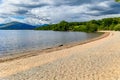 Beautiful beach on the shores of a large fresh water lake surrounded by mountains (Loch Lomond, Scotland
