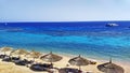 Beautiful beach with strawy parasols and amazing blue sea