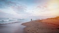 Beautiful beach with a surfer going to the waves early by the morning.