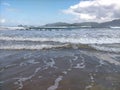 Beautiful beach view with white clouds, blue sky, beautiful waves, clean and clear sea water Royalty Free Stock Photo