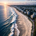 Beautiful beach and water at sunrise with people standing in front of wave and on white sand on the Gold Coast.