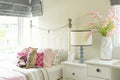 A beautiful bedroom in pastel pink blue with a bedside table with a lamp Royalty Free Stock Photo