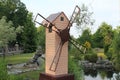 A beautiful beige mill with a brown roof. A small replica of the mill.