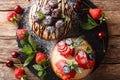 Beautiful berry cakes with chocolate, mint, strawberries, cherries and blueberries close-up. horizontal top view