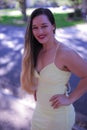 a beautiful big athlete fitness girl in a white dress poses on the street of America against the background of palm trees, in