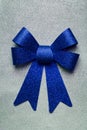 A beautiful big blue bow on a silver glittering background