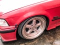 Beautiful big racing wheels of a sports red car with a very low ground clearance on cast shiny expensive alloy wheels in the style Royalty Free Stock Photo