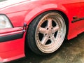 Beautiful big racing wheels of a sports red car with a very low ground clearance on cast shiny expensive alloy wheels in the style