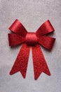 A beautiful big red bow on a silver glittering background.