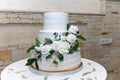 White wedding three-level cake decorated with flowers made of icing Royalty Free Stock Photo